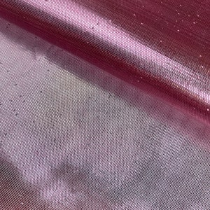 May include: Close-up of a pink glittery mesh fabric. The fabric has a fine, even weave and is shimmering with tiny silver glitter particles.