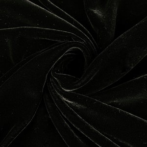 May include: Black velvet fabric with a soft, smooth texture. The fabric is draped and folded, creating a swirling pattern.