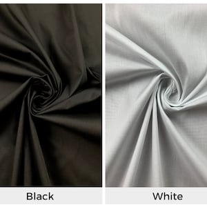 May include: Two fabric swatches, one black and one white, are shown folded and twisted. The fabric is smooth and has a subtle sheen.