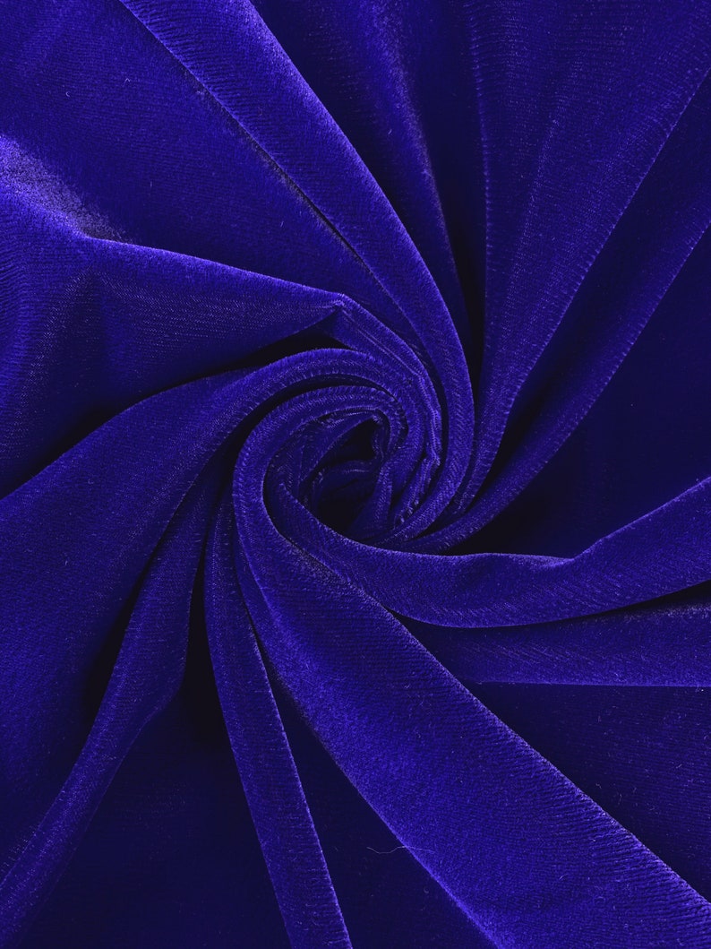 May include: Close-up of a deep blue velvet fabric, showing the soft texture and folds of the material.
