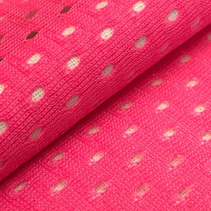 Puede incluir: Tela rosa con un patr&oacute;n de malla blanca. La tela est&aacute; doblada por la mitad, mostrando la textura del material.