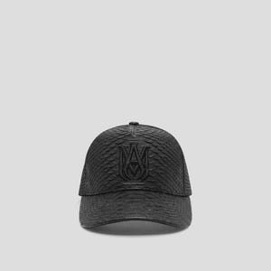 May include: A black baseball cap featuring a textured snakeskin pattern across the crown and brim. The front panel displays a prominent, raised black embroidered logo consisting of the letters MA intertwined in a symmetrical, decorative design.