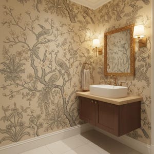 May include: A bathroom vanity area featuring a rectangular white vessel sink mounted on a dark wood cabinet. Above the sink is a gold-framed mirror flanked by two wall-mounted lamps. The walls are covered in cream wallpaper with a gray bird and tree pattern.