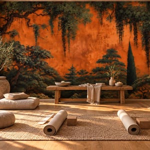 May include: A room featuring a large wall mural of a dark green forest against a vibrant orange background. The space includes a wooden bench, two rolled yoga mats, two yoga blocks, floor cushions, and a potted plant in a large textured vase.