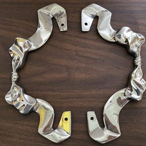 May include: A white ceramic mug with a black handle and the text "But First, Coffee" in a black, handwritten-style font. The mug is on a white surface.