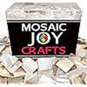 May include: A box labeled "MOSAIC JOY CRAFTS" filled with small, irregularly shaped, off-white mosaic tiles. The box is black with white and red text and a colorful logo. The tiles are scattered around the box.
