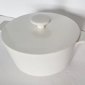 May include: White ceramic casserole dish with a lid and two handles. The lid has a knob on top.