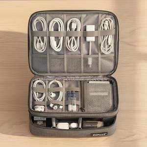 Könnte beinhalten: Ein grauer, rechteckiger Organizer für Elektronikzubehör mit Reißverschluss. Das Innere verfügt über mehrere elastische Schlaufen und Netztaschen für weiße Ladekabel, Adapter, Ohrhörer und kleines technisches Zubehör. Der Markenname WALLE ist deutlich zu sehen.