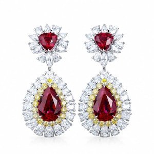 May include: A pair of drop earrings featuring a central pear-shaped red gemstone surrounded by a halo of small yellow and white stones. Above the pear shape is a triangular red stone set within a floral-inspired cluster of white stones.