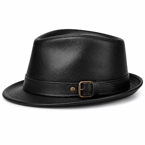 Op de afbeelding: Een zwarte fedora hoed gemaakt van een glad, leerachtig materiaal. De hoed heeft een gestructureerde kroon en een gebogen rand. Een bijpassende zwarte band omsluit de basis, vastgezet met een kleine, messingkleurige metalen gesp en klinknagel.