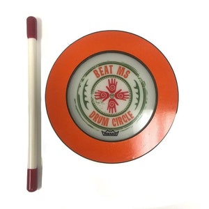 May include: An orange and white drum circle with the text "Beat MS Drum Circle" and the Remo logo. A red and white drumstick is next to the drum circle.