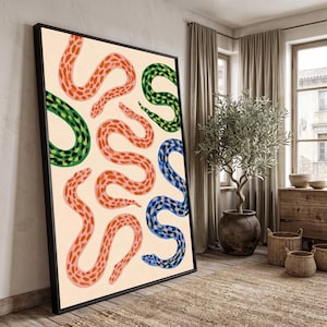 May include: A rectangular framed wall art piece featuring a cream-coloured background with a repeating pattern of stylised snakes in shades of coral, green, and blue. Each snake has a distinct spotted texture and is depicted in a winding, curved position.