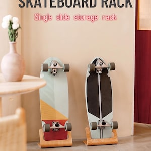 May include: Two light-colored wooden skateboard racks holding skateboards upright. The text SKATEBOARD RACK and Single slide storage rack appear at the top. The racks have a curved base design and are positioned on a floor surface.