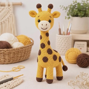 Peut inclure: Une girafe en crochet jaune et marron avec des taches marron foncé, deux petites cornes et un museau crème. La girafe a des yeux de sécurité noirs et un sourire brodé, debout sur quatre pattes avec une petite queue terminée par un pompon.