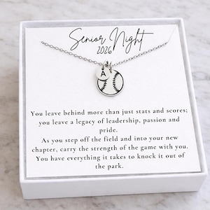 May include: A silver necklace with a baseball pendant and a small round charm with the letter "A". The baseball pendant is white with black stitching. The card reads "Senior Night 2026".