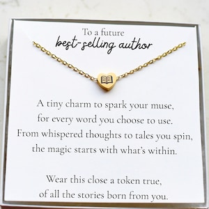 May include: A gold-colored necklace with a heart-shaped pendant featuring a book design. The card reads "To a future best-selling author" with inspirational text about writing and storytelling.