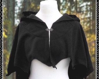 May include: A black hooded cape with a silver clasp closure. The cape is made of a soft, comfortable fabric and has a relaxed fit.