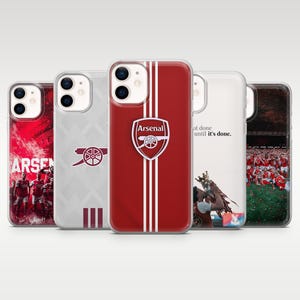 May include: Five phone cases featuring Arsenal Football Club designs. The cases display the team crest, a cannon logo, a red and white striped pattern, a player lifting a trophy with the text 'not done until it's done', and a team celebration.