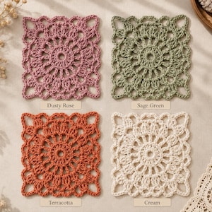 May include: Four square crochet coasters featuring a circular floral pattern with openwork edges. The set includes one dusty rose, one sage green, one terracotta, and one cream coaster, each labeled with its respective color name below it.