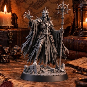 Peut inclure: Une figurine miniature grise non peinte représentant une liche squelettique vêtue de robes en lambeaux, d'une armure à pointes et d'une couronne. La figurine se tient sur un socle en pierre, tenant un grand bâton avec un sommet circulaire.