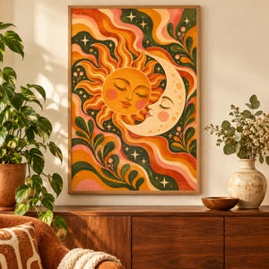May include: A rectangular wall art print featuring a stylized sun and moon with closed eyes, surrounded by wavy bands of orange, red, pink, and dark green. The design includes small white stars and leafy botanical elements throughout the composition.