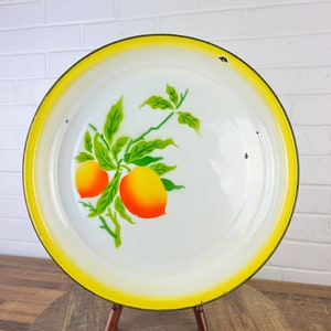 Puede incluir: Bandeja de servir de esmalte blanco con borde amarillo y dise&ntilde;o de c&iacute;tricos verdes y naranjas.