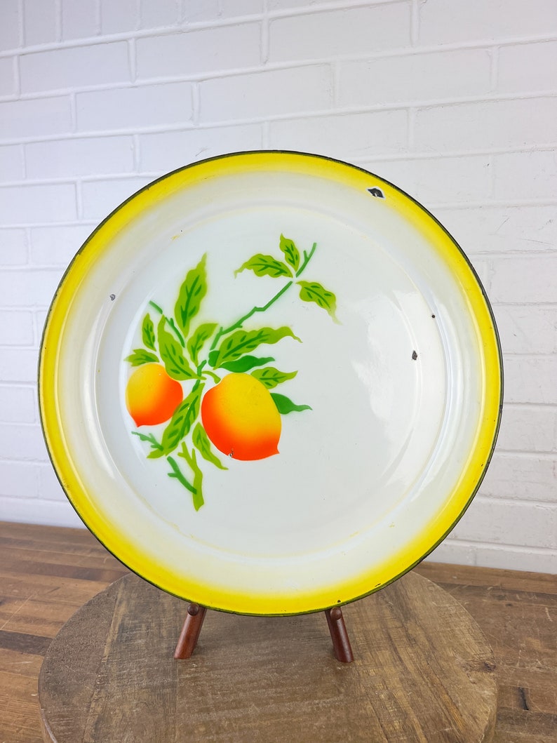 Puede incluir: Bandeja de servir de esmalte blanco con borde amarillo y dise&ntilde;o de c&iacute;tricos verdes y naranjas.