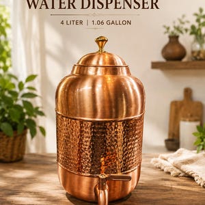 May include: A pure copper water dispenser with a 4 litre or 1.06 gallon capacity. The vessel features a smooth upper section, a hammered midsection, a matching lid with a small knob, and a functional spigot at the base for dispensing water.