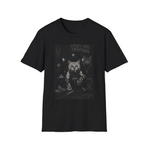 May include: A black short-sleeve t-shirt featuring a graphic print of several cats in a dark setting. The central cat has tattoos and a cigarette, with the text LOYALTY OVER EVERYTHING printed above. The design includes stacks of cash and a firearm.