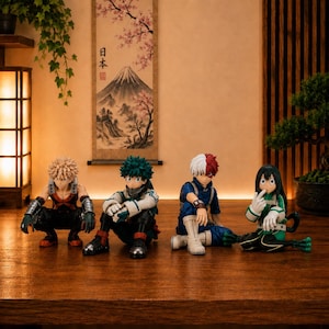 May include: Four My Hero Academia anime character figurines arranged in a row. From left to right, the figures are Katsuki Bakugo with spiky blonde hair, Izuku Midoriya with green hair, Shoto Todoroki with split white and red hair, and Tsuyu Asui.