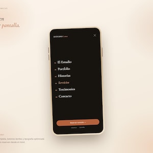 Może przedstawiać: Smartfon wyświetlający interfejs mobilnej strony internetowej w ciemnej kolorystyce dla Estudio Luna. Ekran zawiera menu nawigacyjne z opcjami El Estudio, Portfolio, Historias, Servicios, Testimonios, Contacto oraz przycisk Reservar consulta.