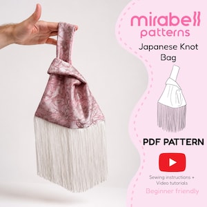 May include: A Japanese knot bag made of pink fabric with a floral pattern and long white fringe at the bottom. The text on the right reads mirabell patterns, Japanese Knot Bag, PDF PATTERN, and Sewing instructions + Video tutorials.