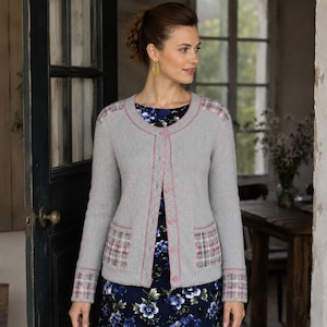 May include: A light gray knit cardigan featuring a round neckline, long sleeves, and a button-down front. The garment includes pink trim along the placket and neckline, with plaid patterned accents on the shoulders, cuffs, and two front pockets.