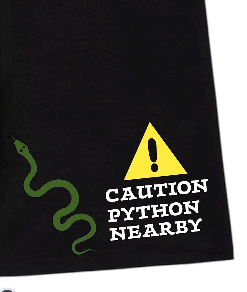 Peut inclure: Un t-shirt noir avec un motif de serpent vert sur le c&ocirc;t&eacute; gauche et un panneau d'avertissement triangulaire jaune avec un point d'exclamation au-dessus du texte blanc CAUTION PYTHON NEARBY en police grasse, carr&eacute;e et sans empattement.