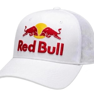 Op de afbeelding: Een witte baseballpet met een mesh achterkant en een gestructureerd voorpaneel. De voorkant toont een geborduurd Red Bull-logo met twee rode stieren die tegenover elkaar staan voor een gele zon, met de tekst Red Bull in rode letters eronder.