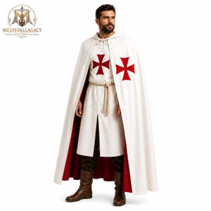 May include: A white hooded cloak with a red interior lining worn over a white tunic featuring two red cross emblems on the chest. The tunic is cinched at the waist with a beige rope belt, paired with dark brown trousers and brown leather boots.