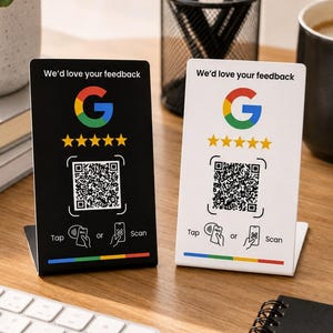 May include: Two rectangular feedback signs, one black and one white, each featuring the Google logo, five yellow stars, a QR code, and the text 'We'd love your feedback' with 'Tap or Scan' instructions and a colorful line at the bottom.