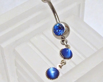 May include: A silver belly button ring with a blue gem and two dangling blue gems.