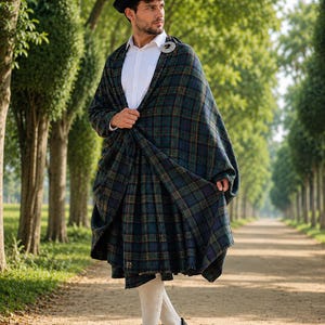 Puede incluir: Una falda escocesa de lana a cuadros azul oscuro y verde con un chal de tartán a juego sobre una camisa blanca de cuello. El conjunto incluye una boina negra, calcetines color crema hasta la rodilla y zapatillas deportivas negras.