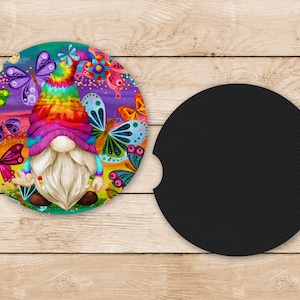 May include: A colorful car coaster featuring a gnome with a rainbow tie-dye hat surrounded by butterflies. The coaster has a black absorbent backing.