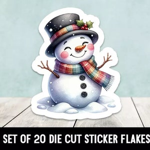 Könnte beinhalten: Ein Set mit 20 ausgestanzten Sticker-Flocken mit einem lächelnden Schneemann, der einen schwarzen Zylinder mit einem rot-grünen karierten Schal trägt. Der Schneemann steht auf einem Schneebett.