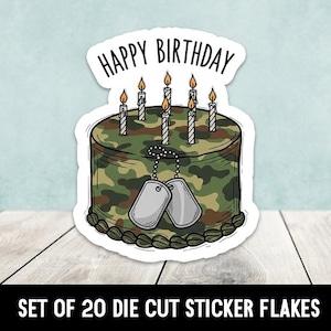 May include: A die-cut sticker featuring a birthday cake with a camouflage pattern. The cake has lit candles and dog tags. The words "HAPPY BIRTHDAY" are above the cake. The sticker is on a white background.