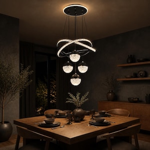 Puede incluir: Una lámpara de araña moderna con un soporte de techo circular negro y cables de suspensión finos. Incluye dos anillos iluminados que se cruzan y cuatro colgantes esféricos con un acabado texturizado similar al cristal que emiten una luz cálida.