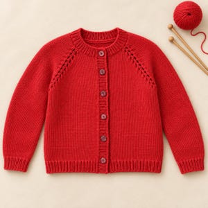 Peut inclure: Un cardigan tricoté rouge vif avec une encolure ronde, des manches longues et une fermeture boutonnée sur le devant avec six boutons assortis. Le vêtement présente un motif ajouré décoratif le long des emmanchures raglan, des poignets et un ourlet côtelés.