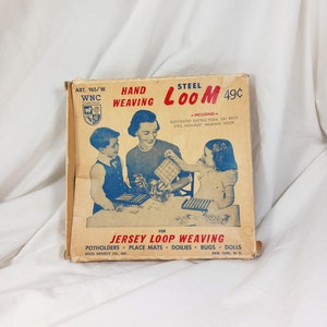 May include: A vintage box for a steel hand weaving loom. The box is yellow with red and blue accents. It features a picture of three children using the loom. The text on the box reads "Steel Loom 49c" and "Hand Weaving". The box also includes instructions for making potholders, place mats, doilies, rugs, and dolls.