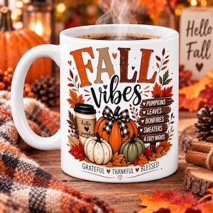 Könnte beinhalten: Ein weißer Keramikbecher mit dem Text FALL VIBES, einer Kaffeetasse, Kürbissen und einem Holzschild mit der Aufschrift PUMPKINS, LEAVES, BONFIRES, SWEATERS & COZY NIGHTS. Der Text am Boden lautet GRATEFUL THANKFUL BLESSED mit kleinen Herzen.