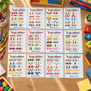 May include: Twelve educational worksheets titled Simple Additions featuring rows of colorful illustrations of objects like animals, fruits, and toys with empty boxes for writing the sum, surrounded by crayons, blocks, and math learning books.