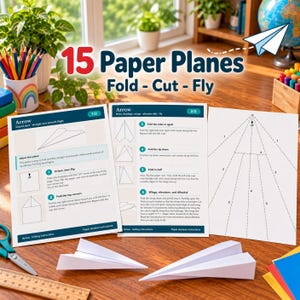 Pode incluir: Um conjunto de folhas de instruções para 15 Paper Planes Fold - Cut - Fly, com diagramas e texto para um modelo Arrow. Dois aviões de papel dobrados brancos estão colocados à frente das instruções, junto a uma régua e uma tesoura.