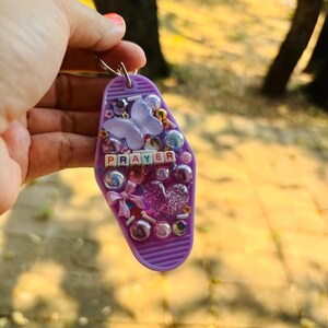 Llavero con oración y una mariposa morada
