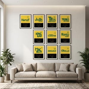 May include: A collection of eleven framed posters arranged on a wall, each featuring a yellow background, a black horizontal band at the bottom, and green text displaying titles of Shakespearean plays including Hamlet, Julius Caesar, and Macbeth.